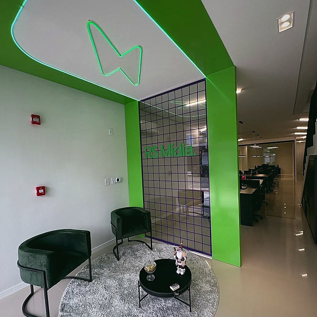 Recepção da RS Mídia com letreiro de neon verde no teto